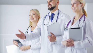 Meslektaşlarının önünde el sıkışan bir erkek doktor.