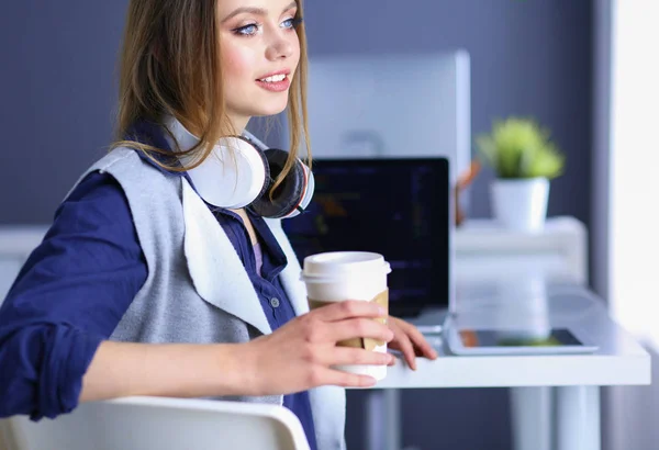 Mladá šťastná žena mluví na mobilním telefonu, zatímco sedí s šálkem kávy — Stock fotografie