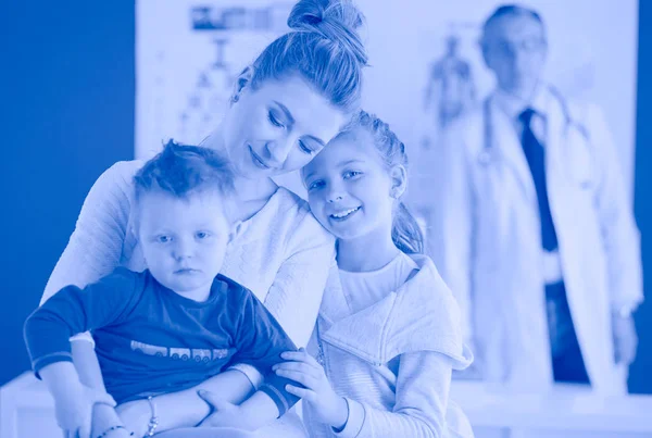 Маленькі діти з матір'ю на консультації до лікаря — стокове фото