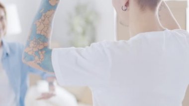 Mutlu bir adam yeni dairesinde kutular arasında sevgilisine sarılıyor ve anahtarı elinde tutuyor.