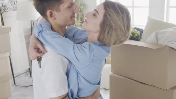 Casal feliz primeira vez compradores proprietários de casa abraçando celebrando dia em movimento — Vídeo de Stock