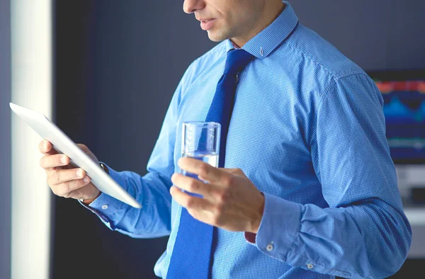 Jeune homme d'affaires sérieux dans les écouteurs regardant l'écran de la tablette — Photo