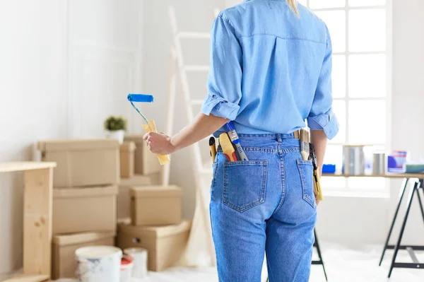 Mulher muito sorridente pintura parede interior de casa com rolo de pintura — Fotografia de Stock