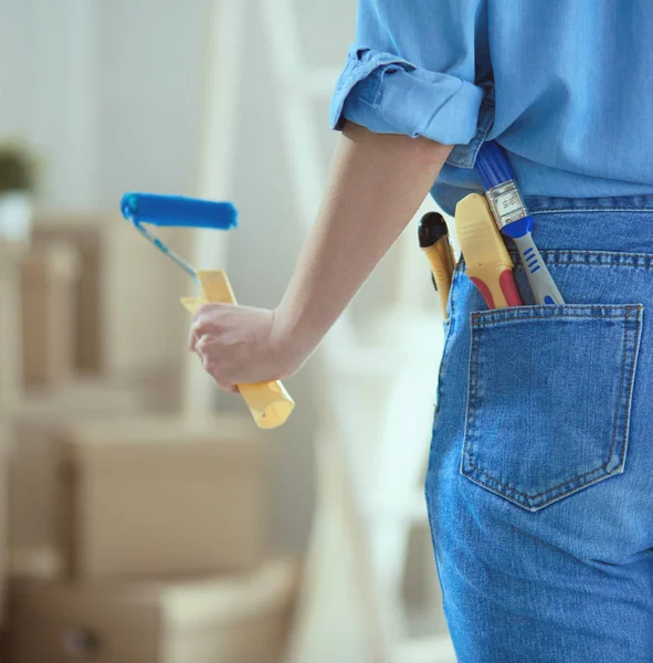 Mujer bonita pintando la pared interior del hogar con rodillo de pintura — Foto de Stock