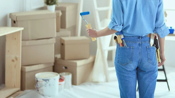 Ganska smilling kvinna målning interiör vägg i hemmet med färg roller — Stockfoto