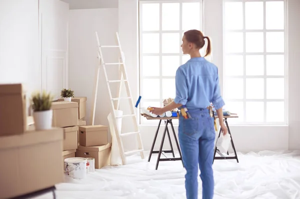 Happy woman paints wall with roller at home — 스톡 사진