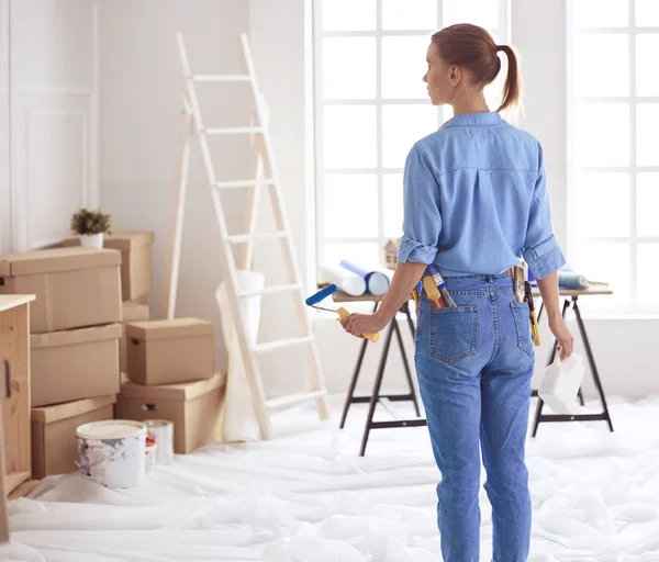 Happy woman paints wall with roller at home — 스톡 사진