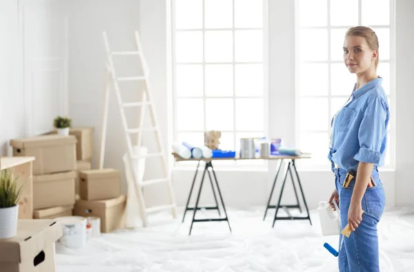 Mujer muy olorosa pintando la pared interior del hogar con rodillo de pintura — Foto de Stock