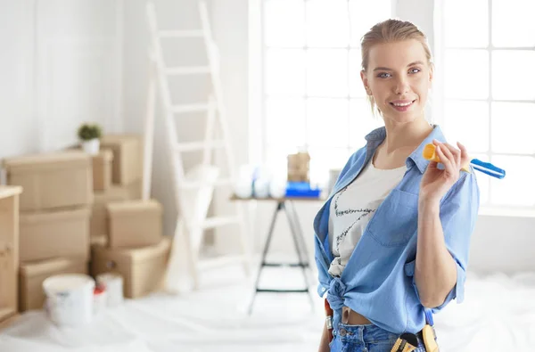 Mujer muy olorosa pintando la pared interior del hogar con rodillo de pintura — Foto de Stock