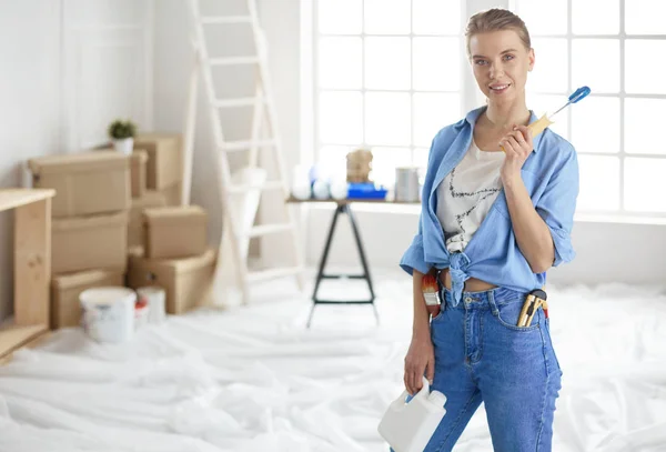 Jolie femme sentant peinture mur intérieur de la maison avec rouleau de peinture — Photo