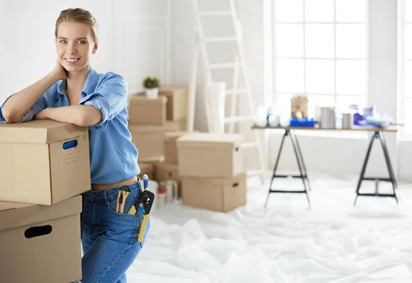 Молодая женщина переезжает из дома в дом, держа картонные коробки — стоковое фото