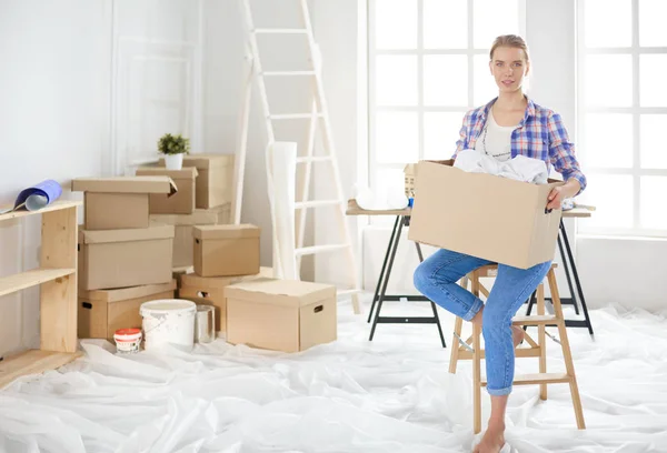 Una hermosa mujer joven soltera desempacando cajas y mudarse a un nuevo hogar —  Fotos de Stock
