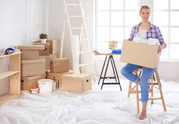En vacker singel kvinna packa upp lådor och flytta in i ett nytt hem — Stockfoto