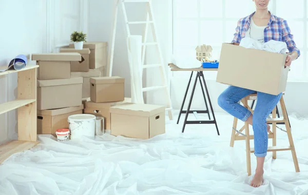 Een mooie alleenstaande jonge vrouw uitpakken dozen en verhuizen naar een nieuw huis — Stockfoto