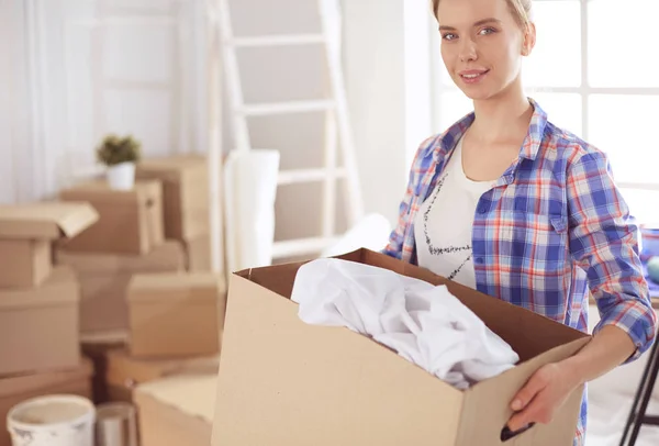 Mujer joven mudanza casa a casa nueva celebración de cajas de cartón —  Fotos de Stock