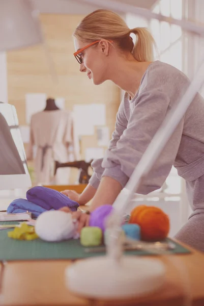 Junge attraktive Modedesignerinnen lehnen am Schreibtisch im Büro und arbeiten mit einem Laptop — Stockfoto