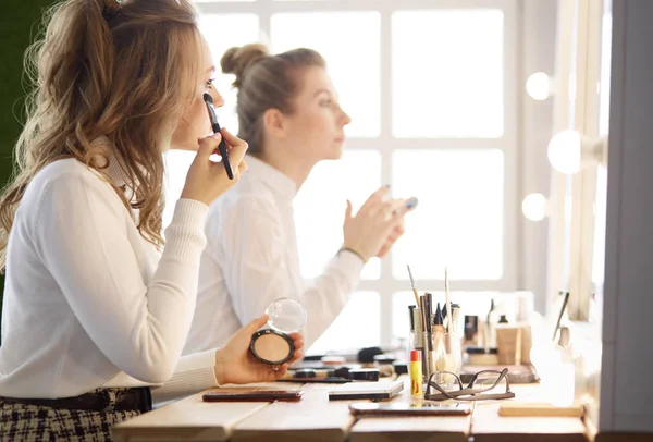 Make up artist facendo professionale make up di giovane donna — Foto Stock