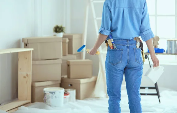 Bella donna sorridente pittura parete interna della casa con rullo di vernice — Foto Stock