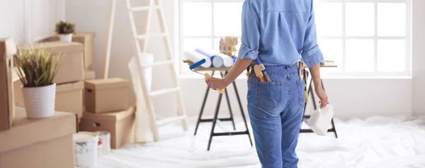 Happy woman paints wall with roller at home — Stock Photo, Image