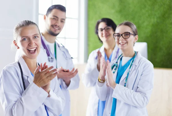 Happy medical team comprising male and female doctors smiling broadly and giving a thumbs up of success and hope — 스톡 사진