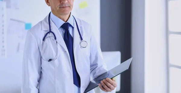 Man dokter schrijft notities op het klembord in het ziekenhuis — Stockfoto