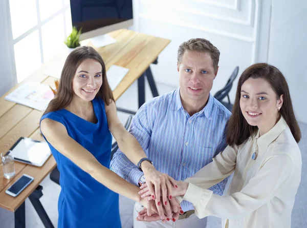 Business colleagues stacking hands together at office — ストック写真