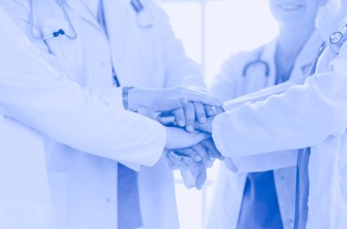 Doktorlar ve hemşireler el ele tutuşuyor. Beyazda izole edilmiş