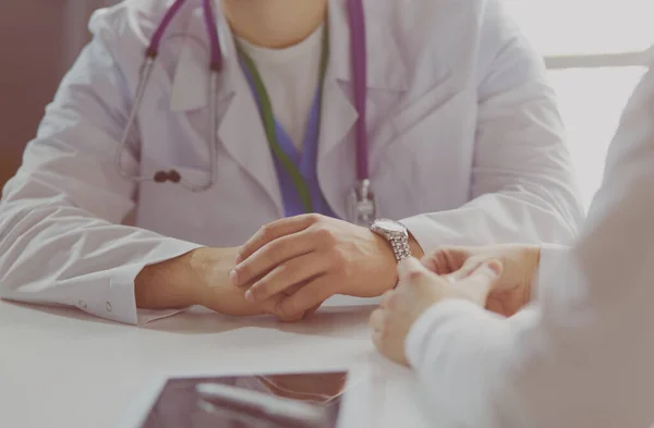 Retrato de um médico do sexo masculino com laptop sentado na mesa no consultório médico — Fotografia de Stock