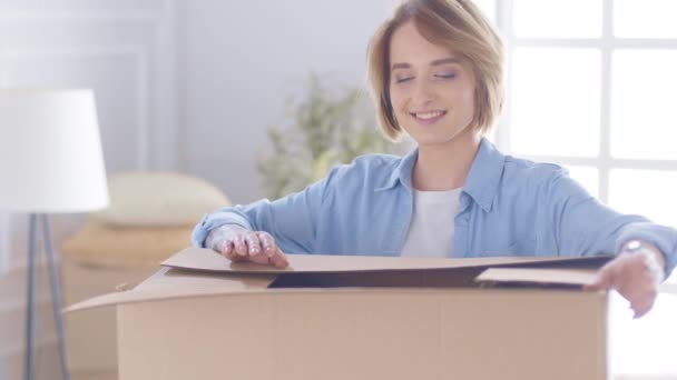 Emocionado caja de cartón abierta mujer joven, feliz cliente femenino recibir paquete de cartón con regalo sentarse en el sofá en casa — Vídeo de stock