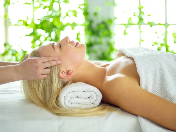 Mujer joven disfrutando de masajes en el salón de spa — Foto de Stock