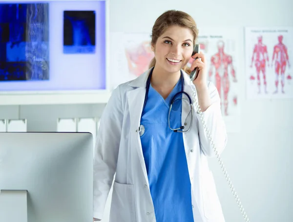 Serieuze dokter aan de telefoon in haar kantoor — Stockfoto