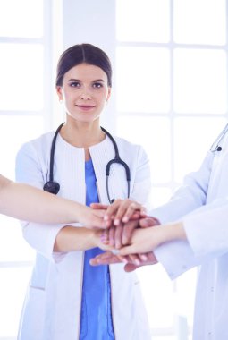 Bir grup doktor ellerini birleştiriyor. Yakın plan.