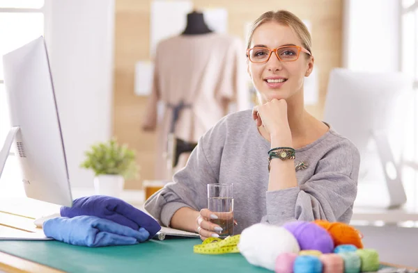 Mulher designer de moda trabalhando em seus projetos no estúdio — Fotografia de Stock