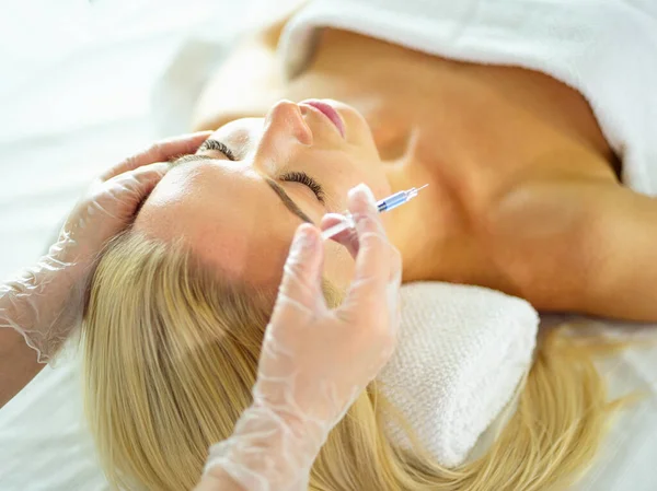 Beautiful woman gets beauty facial injections. Face aging injection. Aesthetic Cosmetology