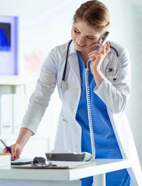 Serieuze dokter aan de telefoon in haar kantoor — Stockfoto