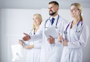 Meslektaşlarının önünde el sıkışan bir erkek doktor.