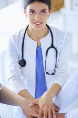 Bir grup doktor ellerini birleştiriyor.