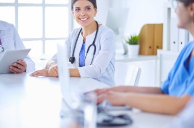 Doktorlar hastane konferans odasında birbirlerine danışıyorlar.