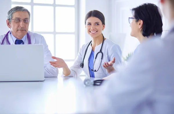 Ciddi bir tıbbi ekip hastaları parlak bir ofiste tartışıyor. — Stok fotoğraf
