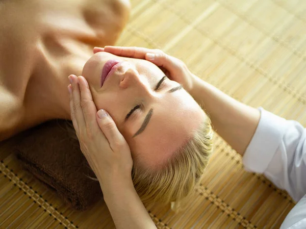 Mulher bonita fazendo massagem facial em um salão de spa — Fotografia de Stock