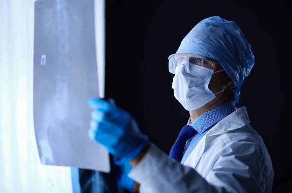 Jovem médico olhando imagem de raio-X em fundo branco isolado — Fotografia de Stock