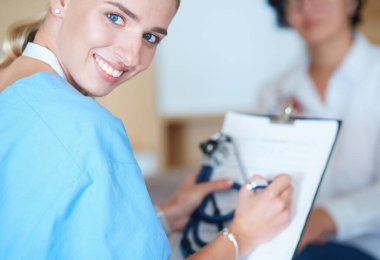 Kadın doktor, kadın hastasına teşhisi açıklıyor.