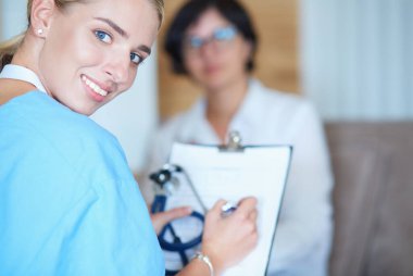 Kadın doktor, kadın hastasına teşhisi açıklıyor.