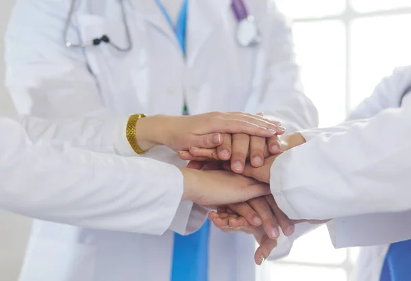 Γιατροί και νοσοκόμες στοιβάζουν τα χέρια τους. Απομονωμένα σε λευκό — Φωτογραφία Αρχείου