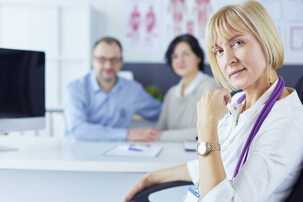 Doctor woman sitting with male patient at the desk