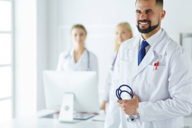 Tıbbi grubun önünde genç bir erkek doktor.