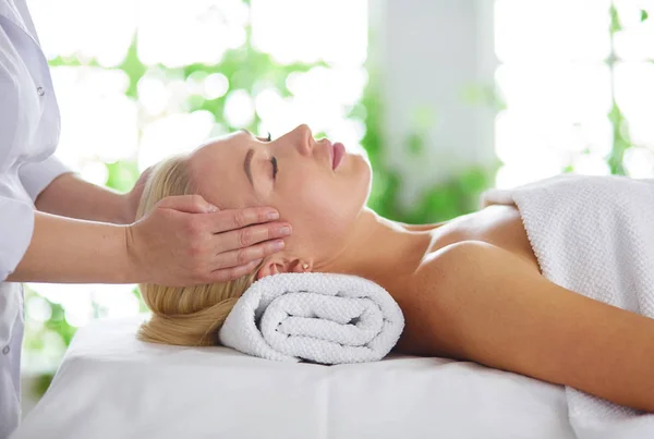 Mujer joven disfrutando de masajes en el salón de spa — Foto de Stock