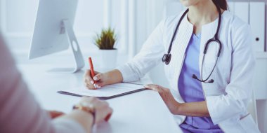 Hastaların lenf bezlerini muayene eden ciddi bir kadın doktor.