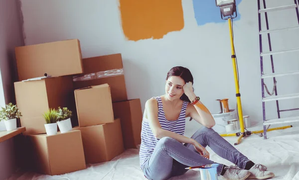 Happy smiling woman painting interior wall of new house. Happy smiling woman — Stock Photo, Image