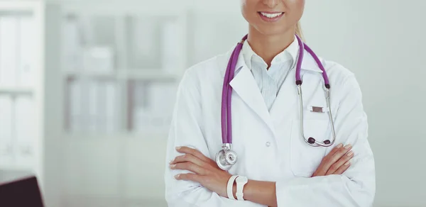Retrato de una joven doctora con una bata blanca de pie en el hospital —  Fotos de Stock